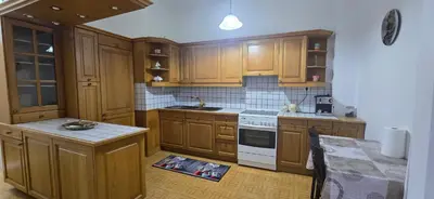 a kitchen with wooden cabinets and white appliances at Jasmine House in Athens