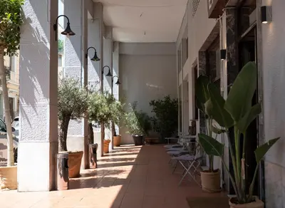 an empty alley with potted plants on the side of a building at The Square Hotel by X&N in Athens