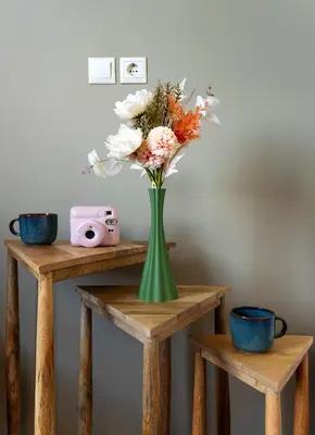 a green vase with flowers sitting on a table at The Square Hotel by X&N in Athens