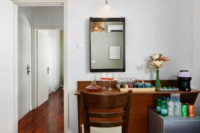 a vanity with a mirror and a table with wine glasses at The Square Hotel by X&N in Athens