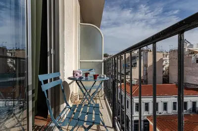 a small table on a balcony with a view of a city at The Square Hotel by X&N in Athens