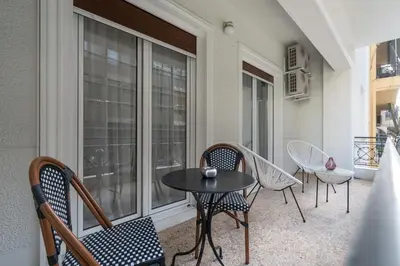a balcony with a table and chairs and a window at Modern apartment near Lycabettus hill with balcony in Athens
