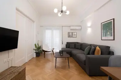 a living room with a couch and a tv at Modern apartment near Lycabettus hill with balcony in Athens