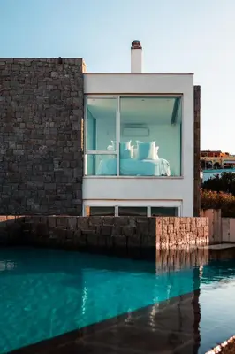 a bed in a window next to a swimming pool at Horizon Luxury Seafront Villa in Vaia
