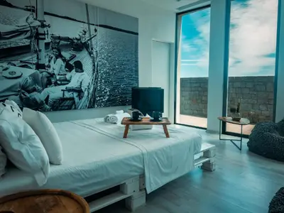 a bedroom with a bed with a tv on a table at Horizon Luxury Seafront Villa in Vaia