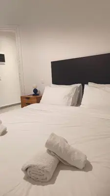 a white bed with a white towel on it at The Blue Apartment in Athens