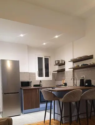 a kitchen with a refrigerator and a table and chairs at The Blue Apartment in Athens
