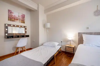 a bedroom with two beds and a chair and a mirror at Downtown Kolonaki Getaway - 1BR Apartment by ΜΡS in Athens