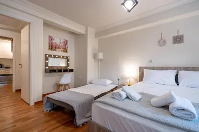 a bedroom with two beds and a living room at Downtown Kolonaki Getaway - 1BR Apartment by ΜΡS in Athens