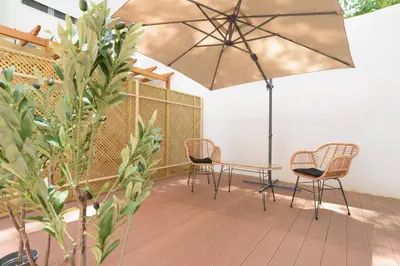 a patio with chairs and a table and an umbrella at Stylish elevated ground floor studio with yard in Athens