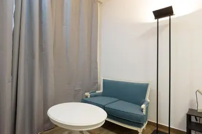 a blue chair and a table in a room at Stylish elevated ground floor studio with yard in Athens