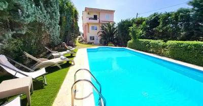 a swimming pool with chairs and a house at Luxury villa El Verano with private pool in Kalívia Thorikoú