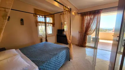 a bedroom with a canopy bed with a balcony at Luxury villa El Verano with private pool in Kalívia Thorikoú