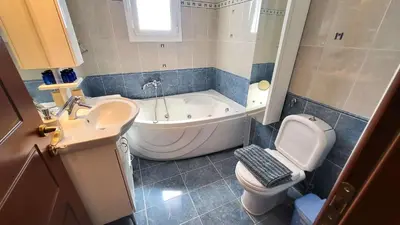 a bathroom with a tub and a toilet and a sink at Luxury villa El Verano with private pool in Kalívia Thorikoú