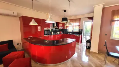 a kitchen with a red island in the middle at Luxury villa El Verano with private pool in Kalívia Thorikoú