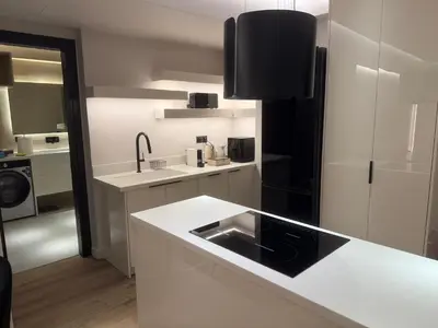 a kitchen with white counters and a black refrigerator at Πολυτελής απόδραση στην Γλυφάδα in Athens
