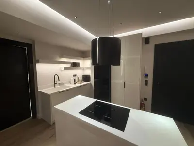 a kitchen with a white counter and a black refrigerator at Πολυτελής απόδραση στην Γλυφάδα in Athens