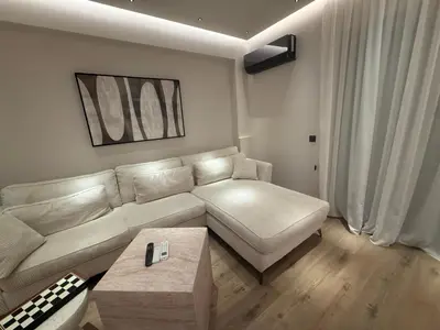 a living room with a couch and a table at Πολυτελής απόδραση στην Γλυφάδα in Athens