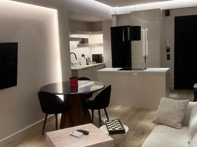 a living room with a table and chairs and a kitchen at Πολυτελής απόδραση στην Γλυφάδα in Athens