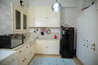 a kitchen with white cabinets and a black refrigerator at La Boheme stylish Flat i in Athens