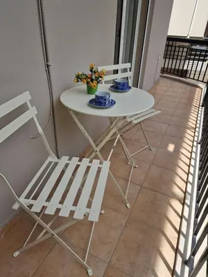 a white table and two chairs on a balcony at The Argy Apartment in Athens