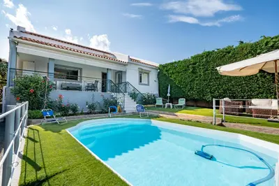 a swimming pool in front of a house at 4 Bedroom Villa with private pool in Lagonisi in Áyios Nikólaos