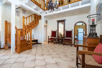 a living room with a staircase and chairs at 4 Bedroom Villa with private pool in Lagonisi in Áyios Nikólaos