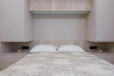 a bedroom with a large bed with white cabinets at Viorelia's Home in Athens
