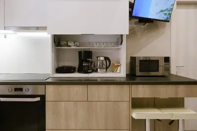 a kitchen counter with a microwave and a coffee maker at Viorelia's Home in Athens