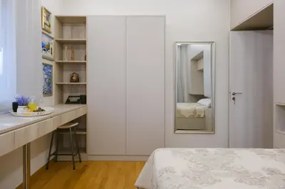 a white bedroom with a bed and a mirror at Viorelia's Home in Athens