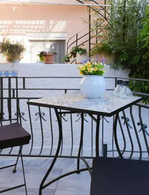 a table with a vase of flowers on it at Viorelia's Home in Athens