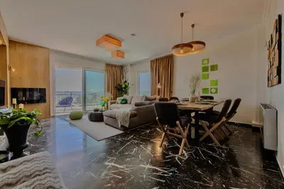 a living room with a table and a couch at Alimos Marina Home - Luxury Corner SeaView Apartment in Athens