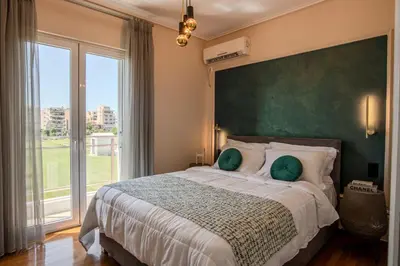 a bedroom with a large bed with a large green headboard at Alimos Marina Home - Luxury Corner SeaView Apartment in Athens