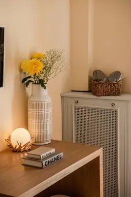 a table with a vase and a stack of books at Alimos Marina Home - Luxury Corner SeaView Apartment in Athens