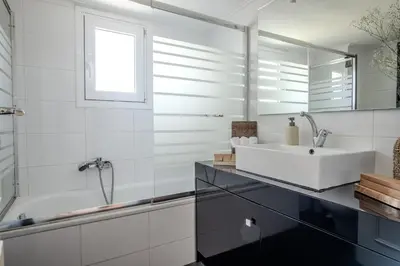 a white bathroom with a sink and a tub at Alimos Marina Home - Luxury Corner SeaView Apartment in Athens