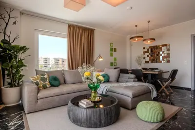 a living room with a couch and a table at Alimos Marina Home - Luxury Corner SeaView Apartment in Athens