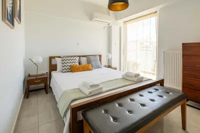 a bedroom with a large bed and a window at Urban Comfort near Piraeus Port D3 in Piraeus