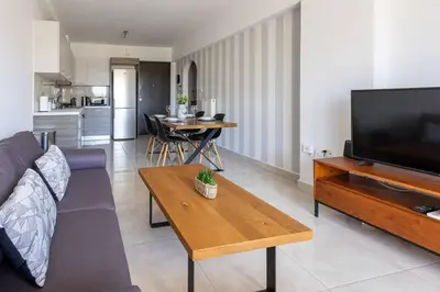 a living room with a couch and a tv and a table at Urban Comfort near Piraeus Port D3 in Piraeus