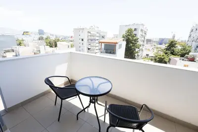a balcony with two chairs and a table at Urban Comfort near Piraeus Port D3 in Piraeus