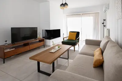 a living room with a couch and a flat screen tv at Waylink Residences-Piraeus Port DRA in Piraeus
