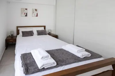 a bedroom with a white bed with towels on it at Waylink Residences-Piraeus Port DRA in Piraeus