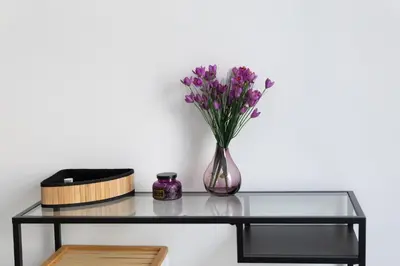 a glass table with a vase with purple flowers at Waylink Residences-Piraeus Port DRA in Piraeus