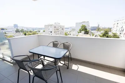 a table and chairs on a balcony with a view at Waylink Residences-Piraeus Port DRA in Piraeus