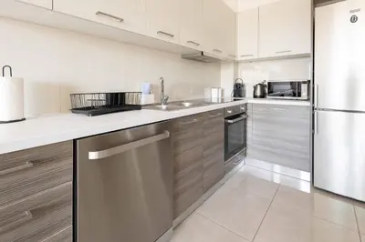 a kitchen with wooden cabinets and stainless steel appliances at Modern Stay near Piraeus Port E3 in Piraeus