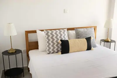 a bedroom with a bed with white sheets and pillows at Modern Stay near Piraeus Port E3 in Piraeus