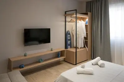 a bedroom with a tv and a dresser with a bed at Pop Art Apartment in Piraeus in Piraeus
