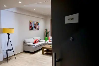 a living room with a couch and a table at Pop Art Apartment in Piraeus in Piraeus