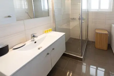 a white bathroom with a sink and a shower at Modern Apartment in Piraeus Port D2 in Piraeus