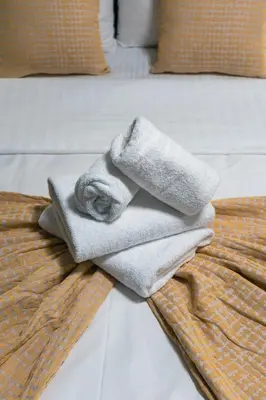 a pile of towels sitting on top of a bed at Urban Nest in Trendy Koukaki in Athens