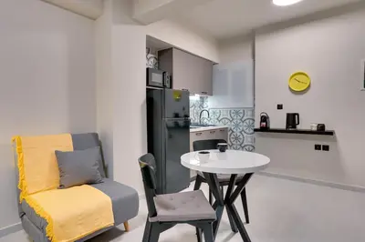 a kitchen with a table and a chair and a small table and a refrigerator at Urban Nest in Trendy Koukaki in Athens